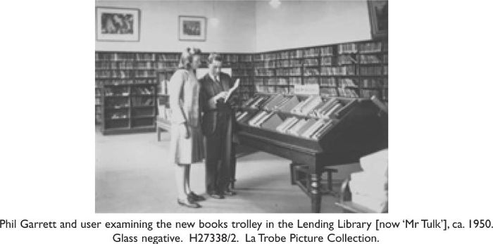 Phil Garrett and user examining the new books trolley in the Lending Library [now ‘Mr Tulk’], ca. 1950. Glass negative. H27338/2. La Trobe Picture Collection. [photograph]